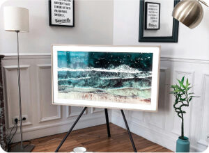 Modern living room corner with framed ocean artwork on tripod stand and stylish decor.