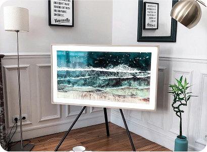 Modern living room corner with framed ocean artwork on tripod stand and stylish decor.