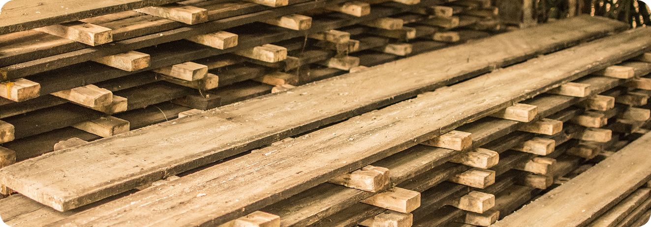 A close-up view of a rich, dark wood surface with visible grain patterns.